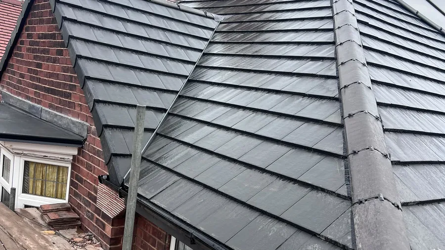 Hipped roof re-covered in grey tiles beside the chimney