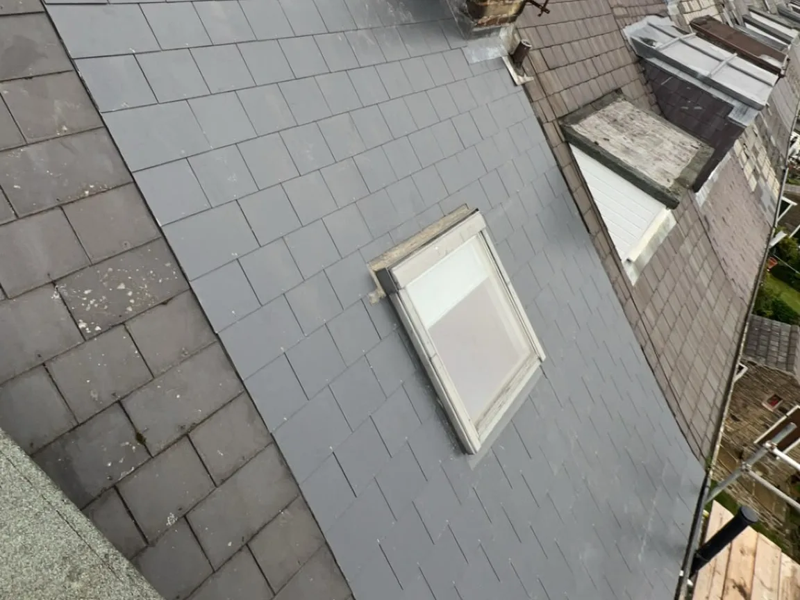 Roof window set back into a newly slated roof